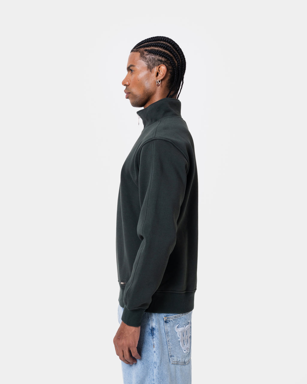 Model wearing FAT QUNTO HALFZIP BLACK in loose fit with short zipper, side view, highlighting soft inner layer.