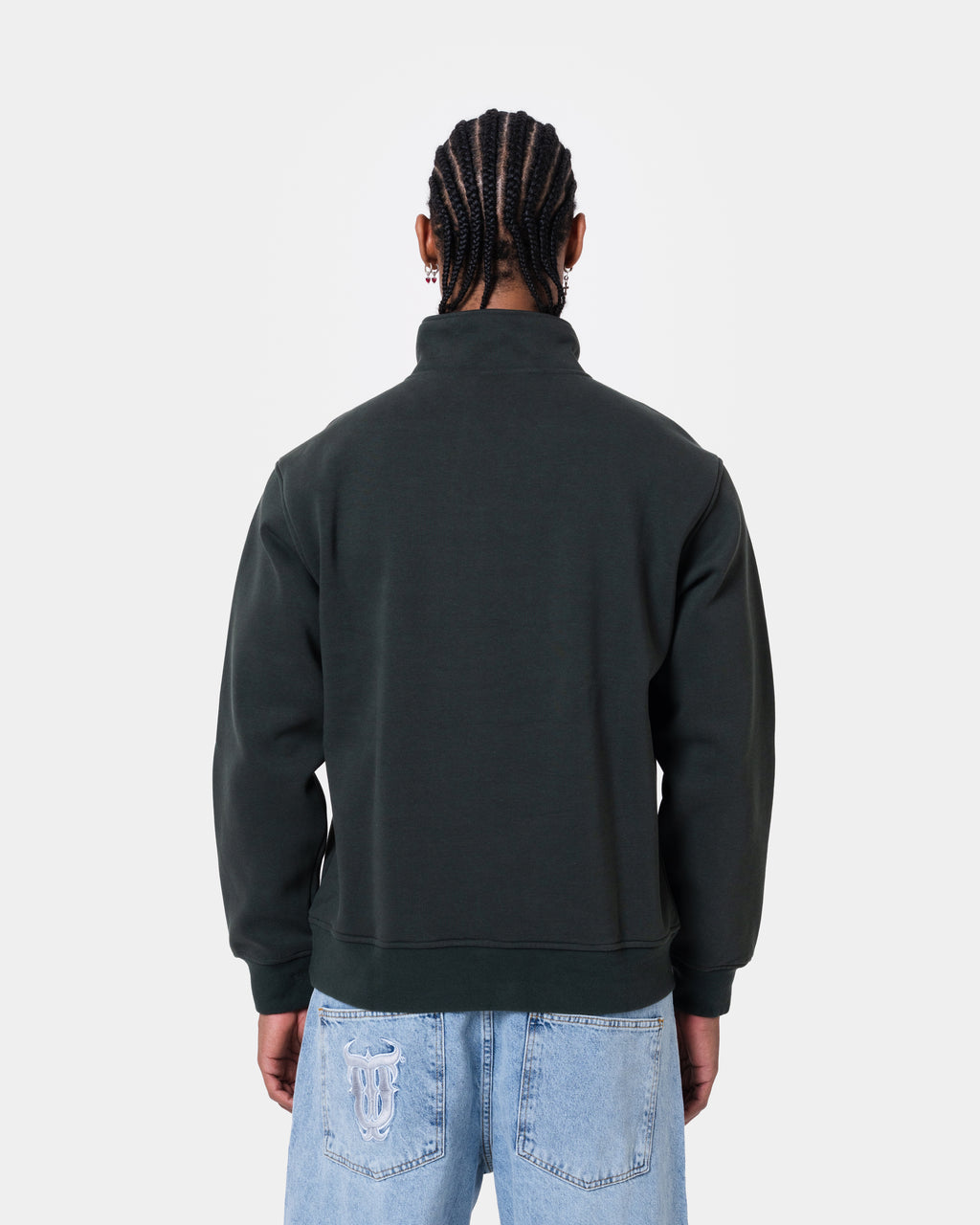 Back view of a man wearing FAT QUNTO HALFZIP BLACK, a loose fit short zipper sweatshirt in black.