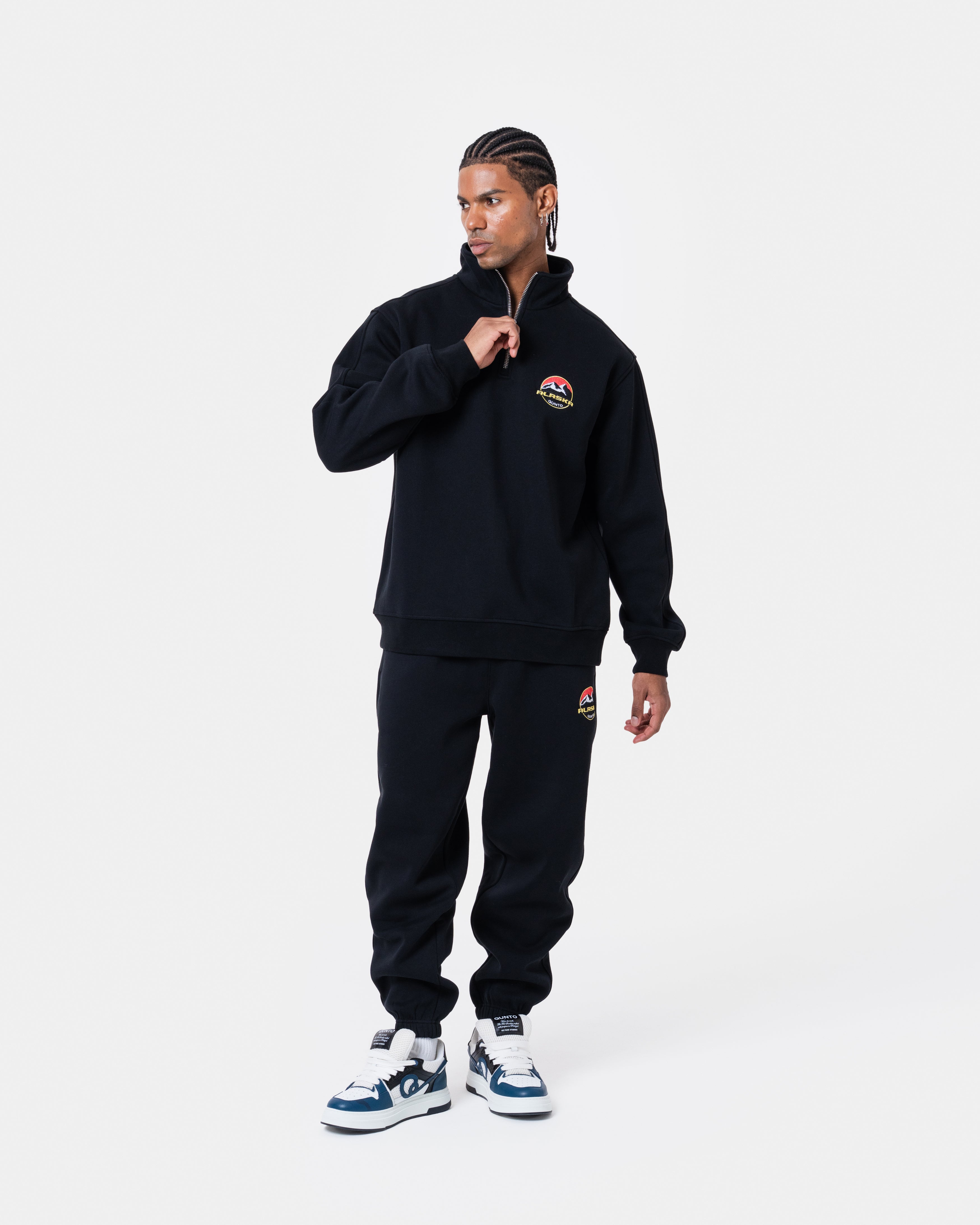 ALASKA BADGE BLACK HALFZIP worn by model in black outfit with soft inner layer and metal plate design.