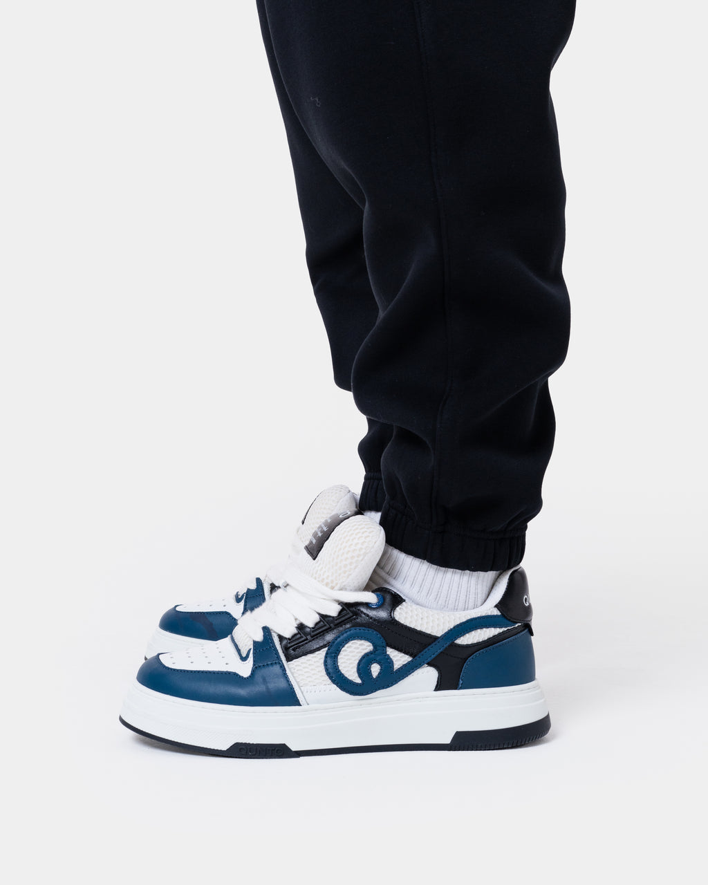 ALASKA BADGE BLACK JOGGER worn with stylish blue and white sneakers, showcasing a casual and trendy outfit.